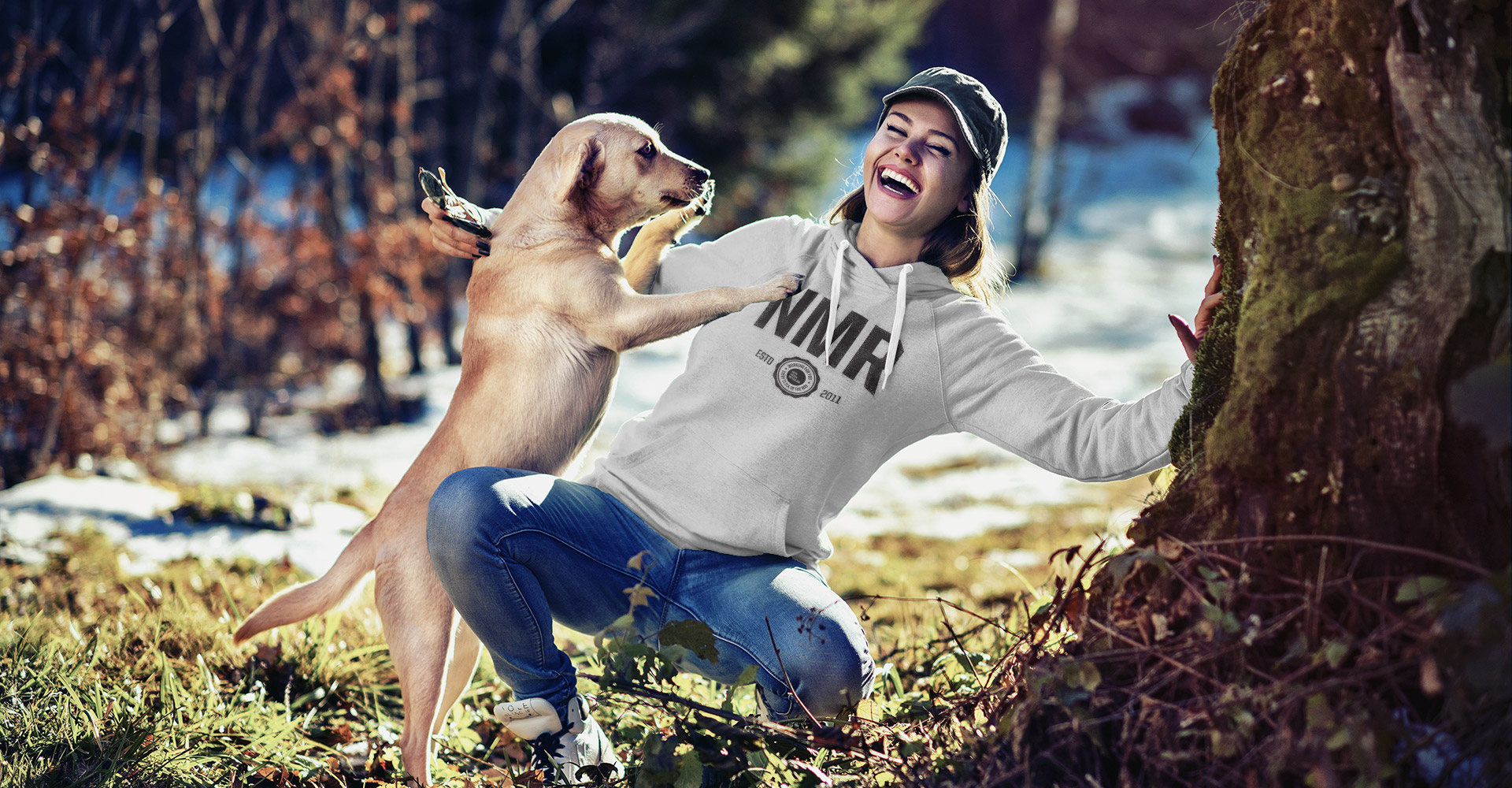 Photo of a woman in a hoodie playing with a dog